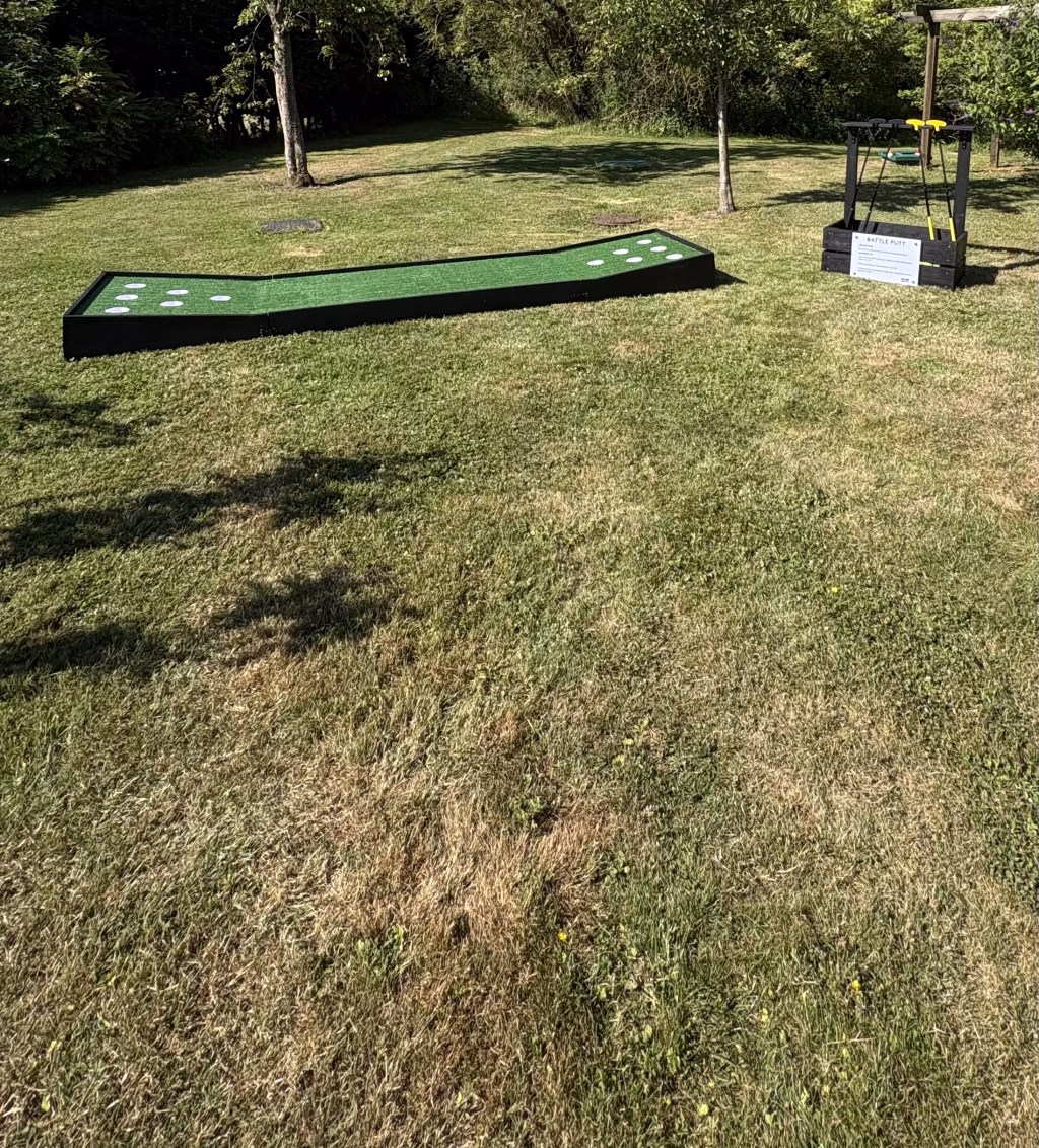 Battle Putt outdoor mini golf game set up for weddings, party and corporate event hire in Norfolk, Suffolk and East Anglia with club stand and rule sign