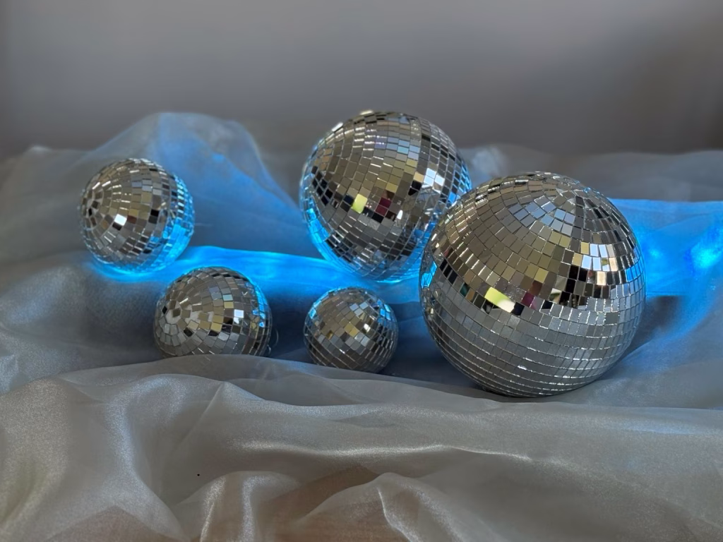 Mirrorballs illuminated with blue lighting for contemporary event styling.