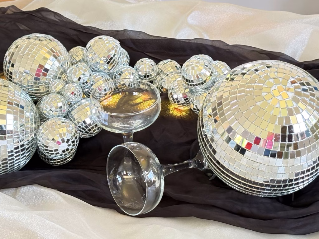 Luxury mirrorball styling with champagne coupes creating contrast and texture.