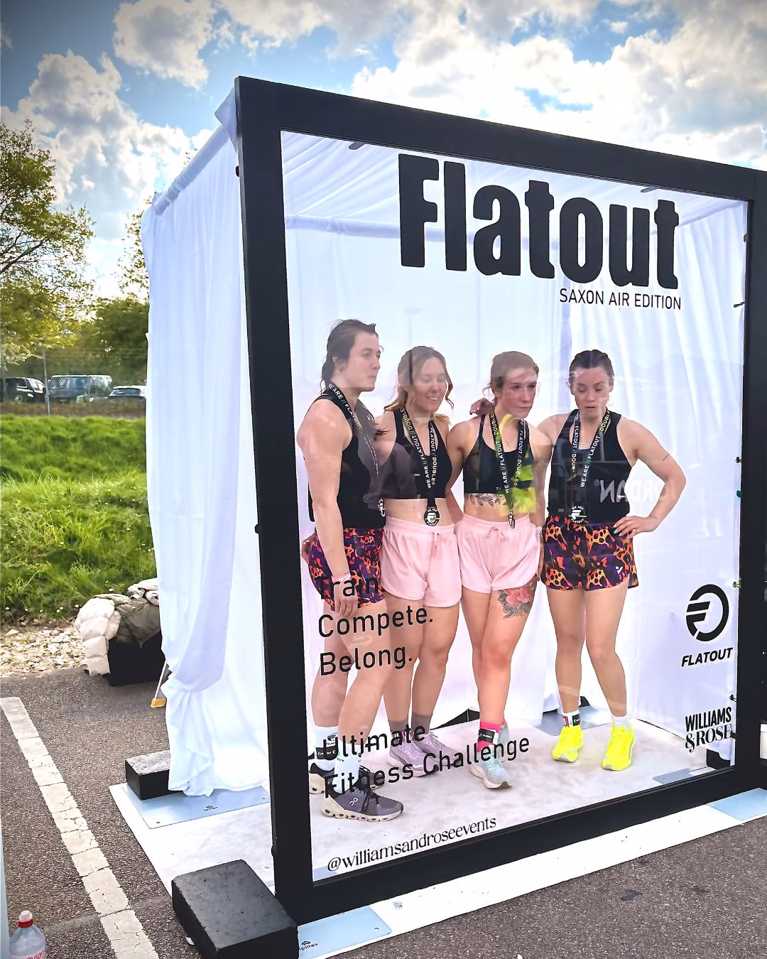 Magazine Booth outdoors at Saxon Air for WE ARE FLATOUT with competitors taking their finisher photos with their medals