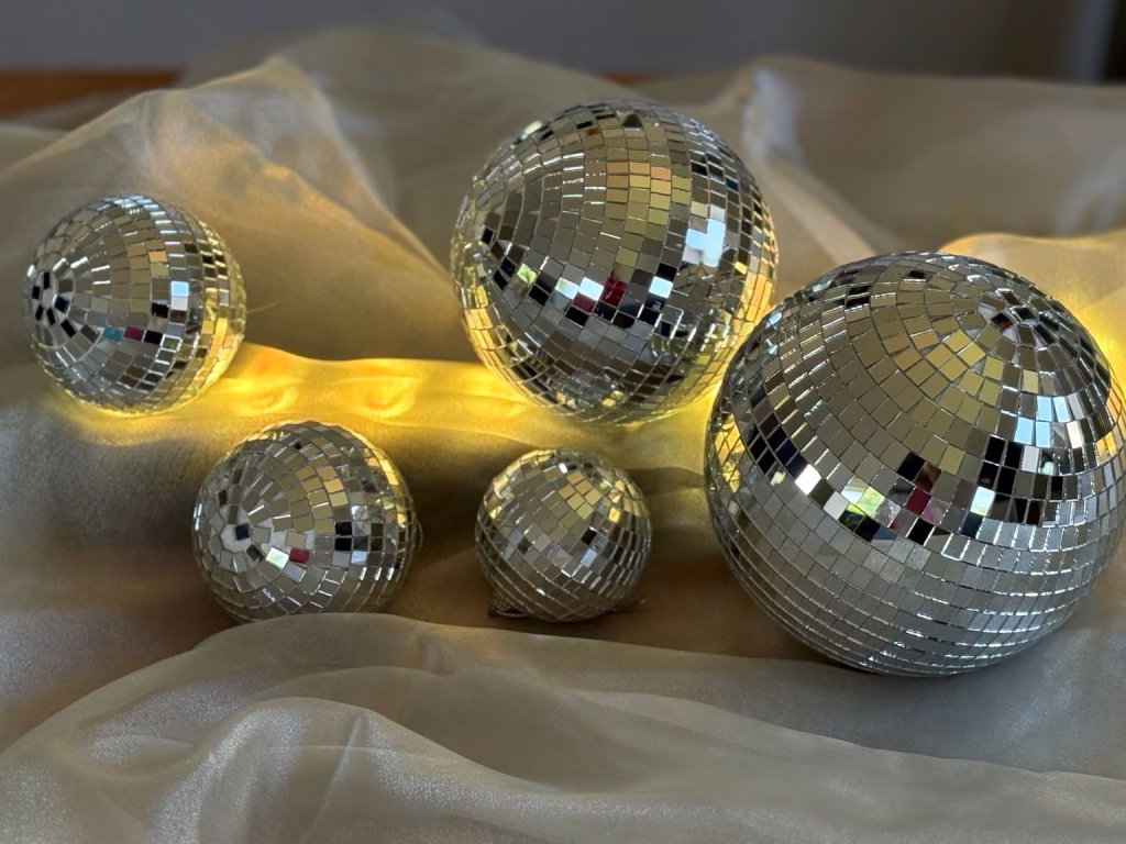Mirrorballs illuminated with warm golden lighting for atmospheric event styling.