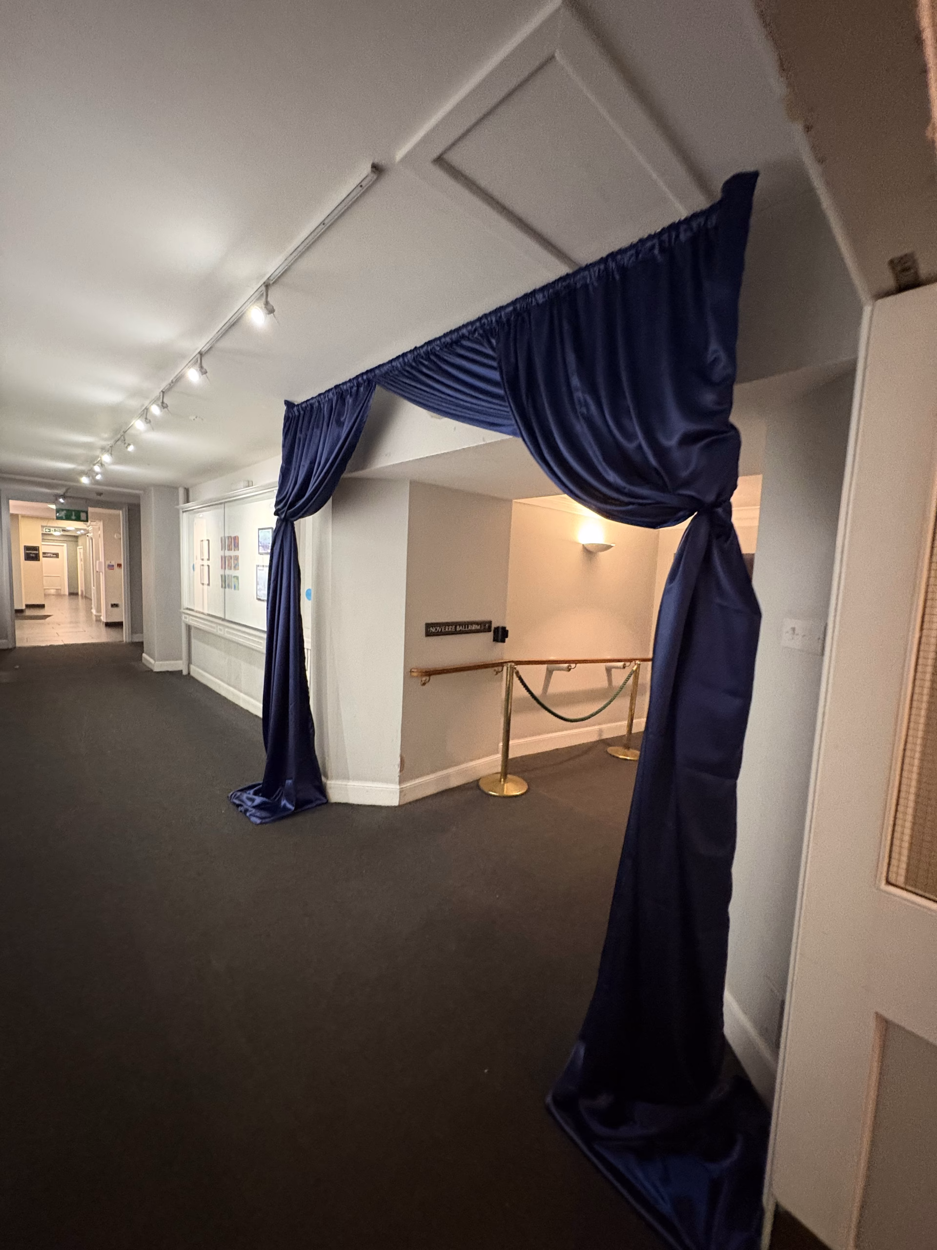 Dark Blue draped entrance hall leading to charity gala dinning area