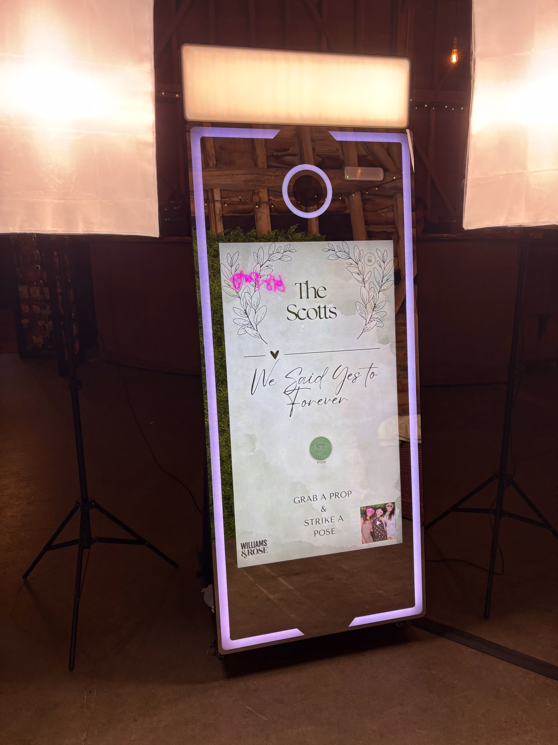 Front on look at the magic mirror photo booth displaying a custom homescreen to welcome wedding guests to the booth for the evening including a live gallery view