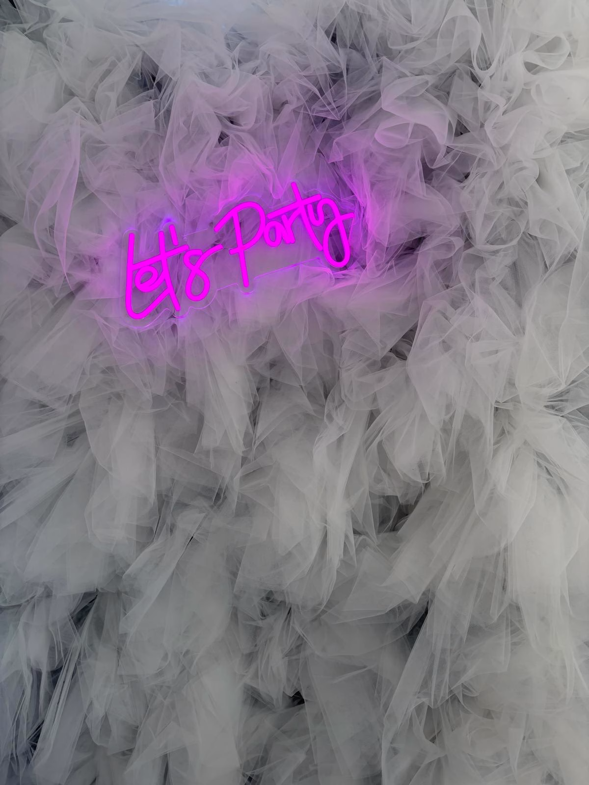 Close up of our latest backdrop the Tulle Wall with Pink Neon Lets Party Sign